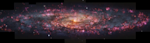 A huge disk spiral galaxy scattered with pink light to show the ionised hydrogen star-forming regions and becoing more orange-yellow towards the center of the spiral