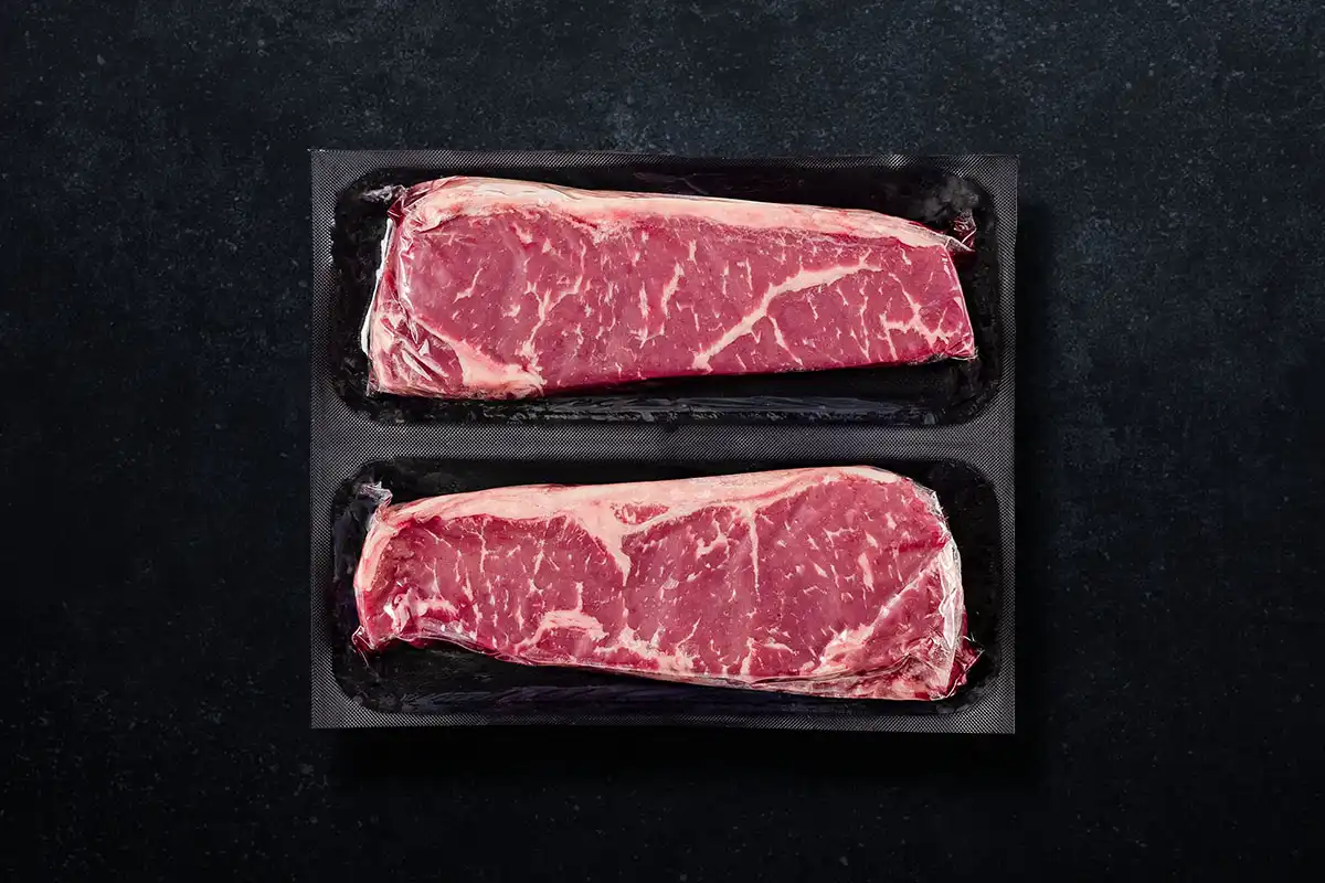 Packaged NY Strips on black background