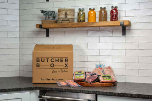 A ButcherBox with a variety of products sitting on a modern kitchen counter.