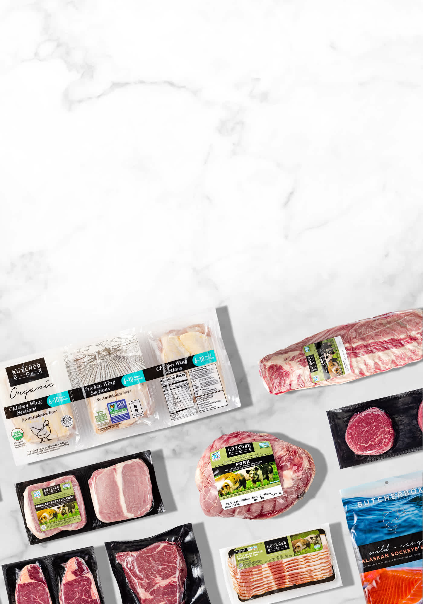 A flatlay of ButcherBox products in packaging on marble background