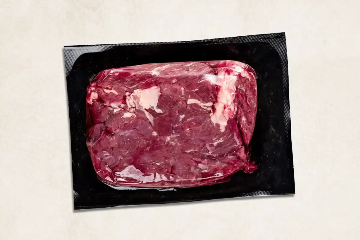 Packaged steak tips on blue background