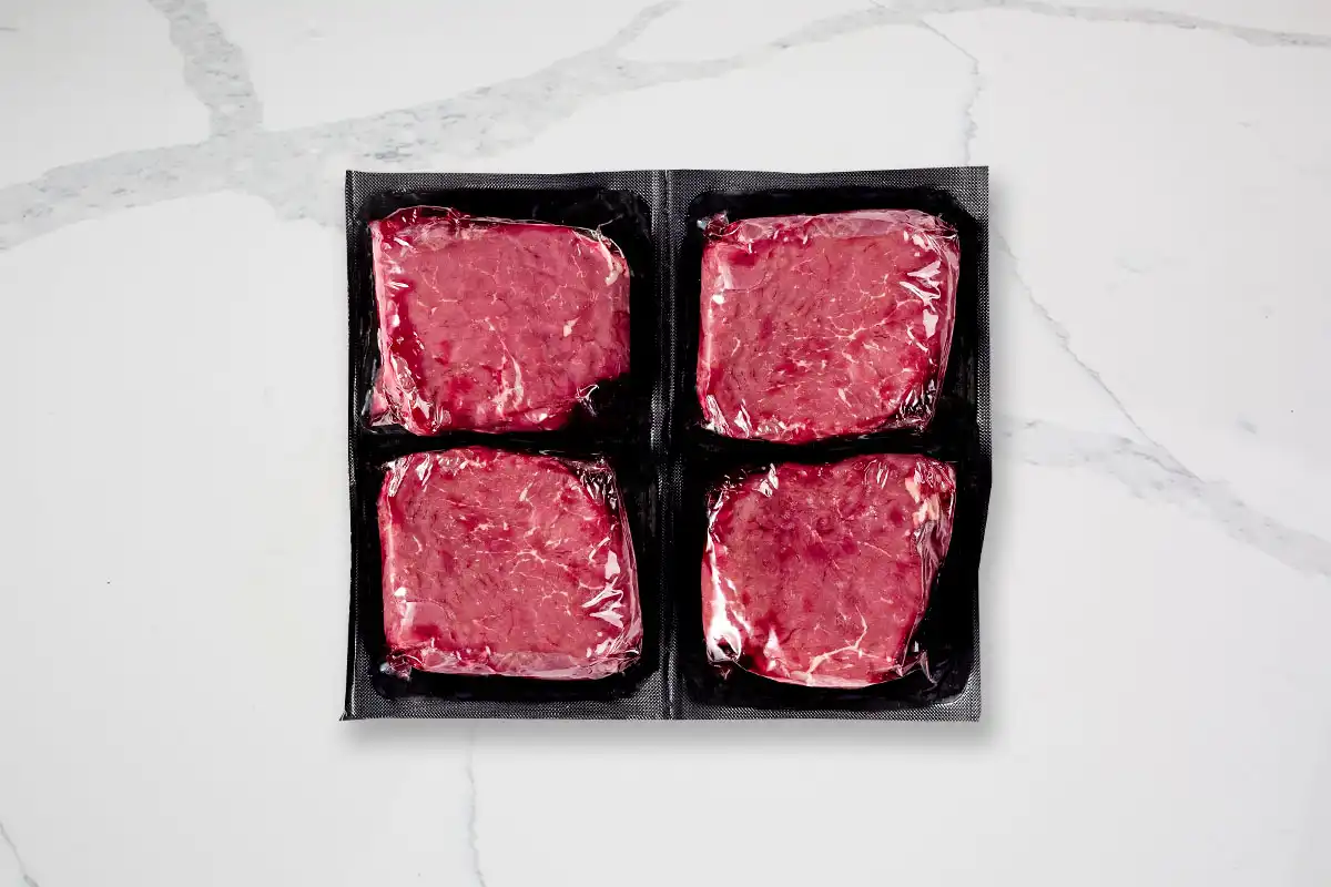 Packaged top sirloins on marble background