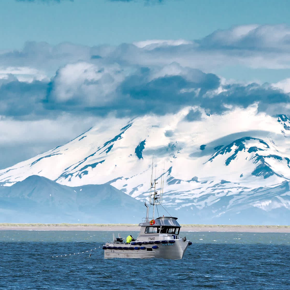 Boat in ocean in front of snowy mountain