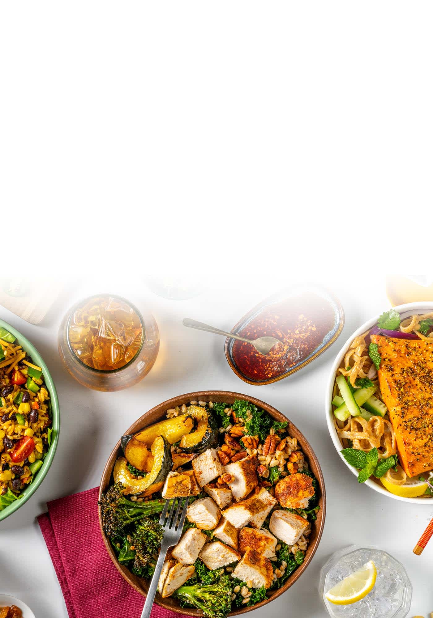 Plates of ground beef taco bowl, chicken and squash salad, and salmon noodle bowl