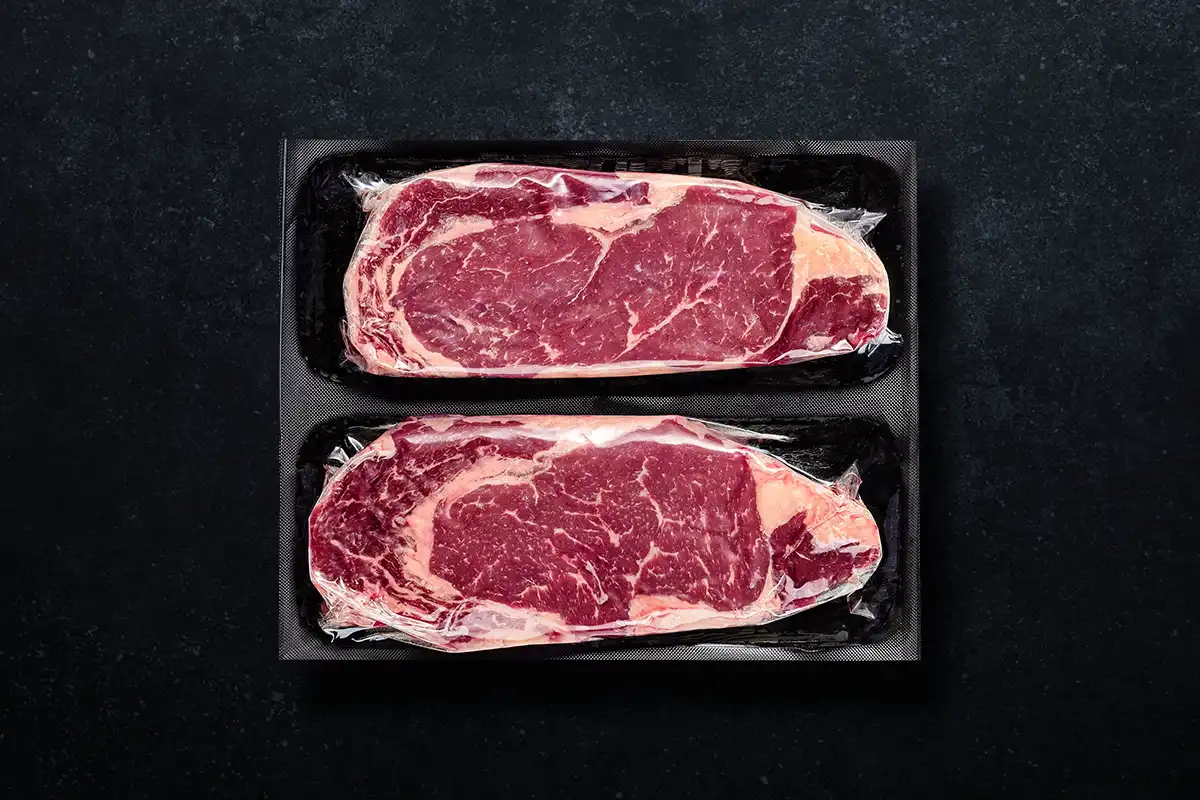 Packaged ribeye on black background