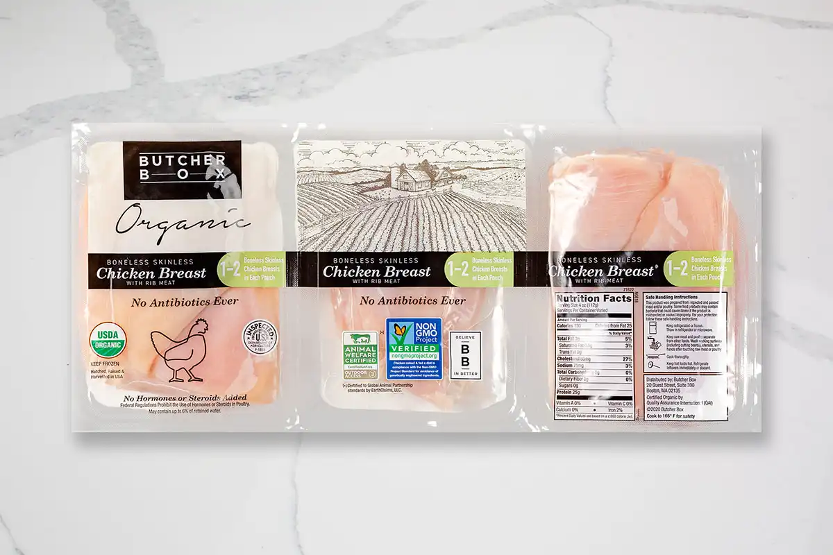 Packaged chicken breasts on marble background