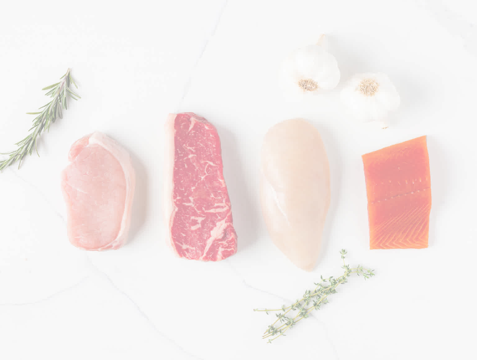 raw pork, steak, chicken and salmon on marble countertop
