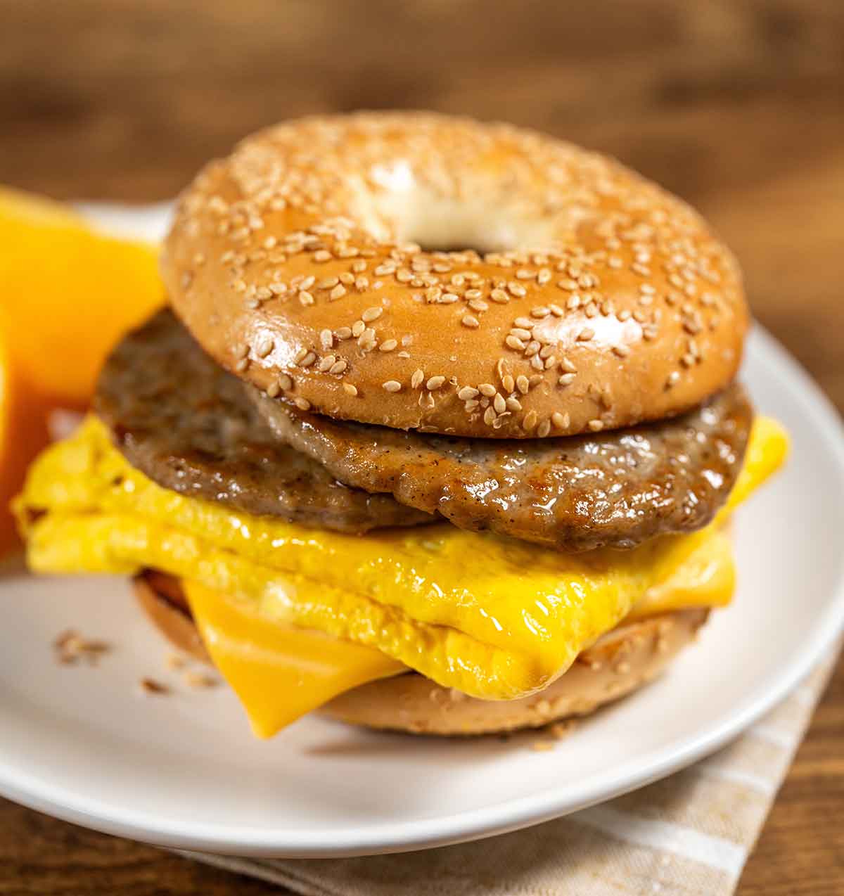 A tasty bagel sandwich filled with sausage and eggs for breakfast.