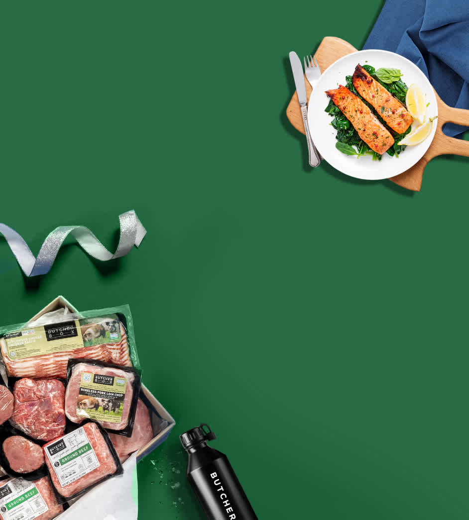 ButcherBox gift box of bacon, pork, and beef with a plate of cooked salmon on a green background