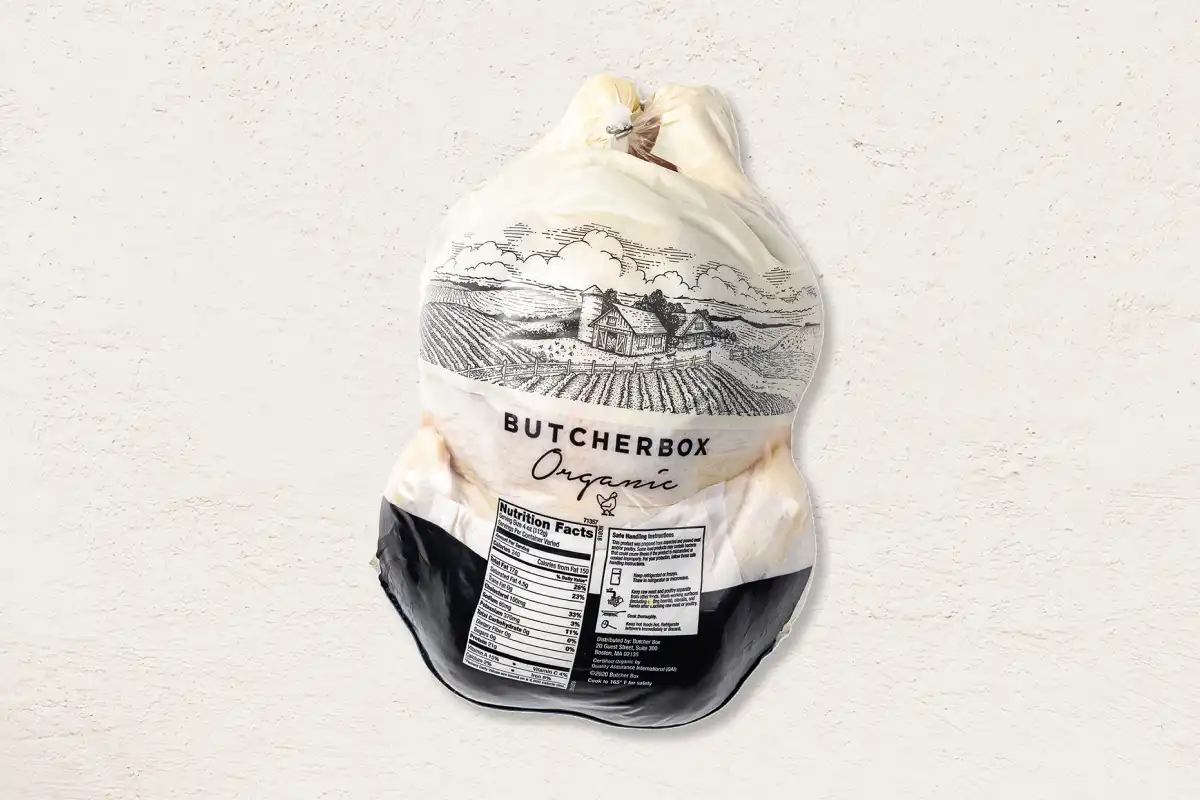 Packaged whole chicken on beige background