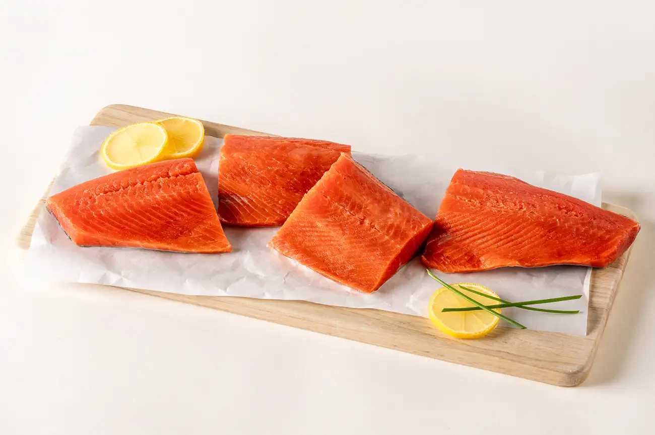 4 pieces of wild caught salmon on a cutting board