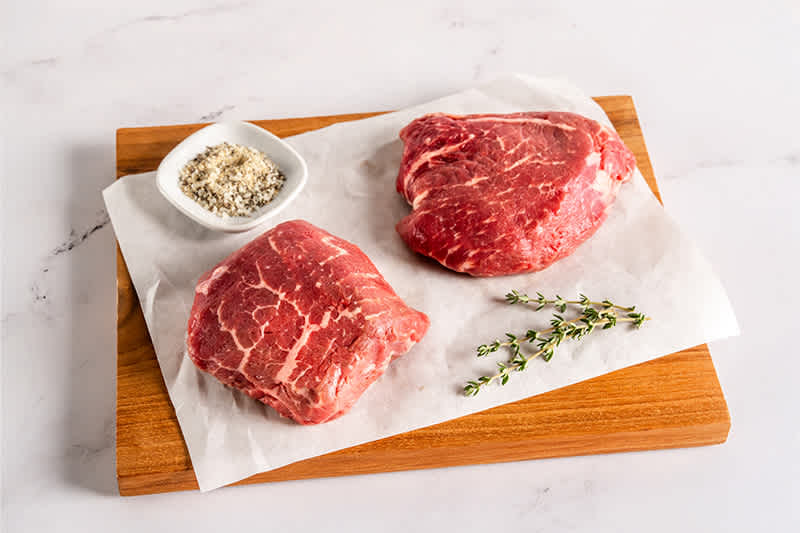 U.S. Pasture Raised Top Sirloin sitting on a wooden board.
