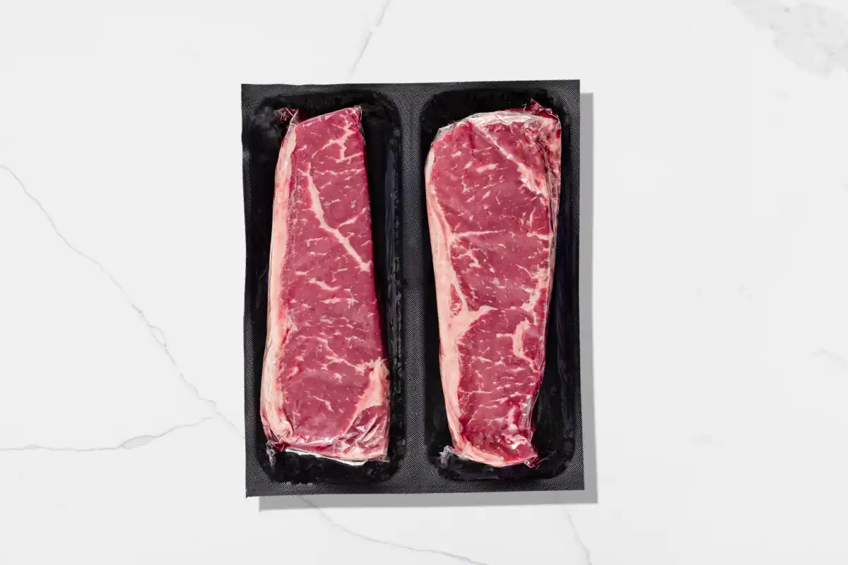 Packaged NY strips on a marble background