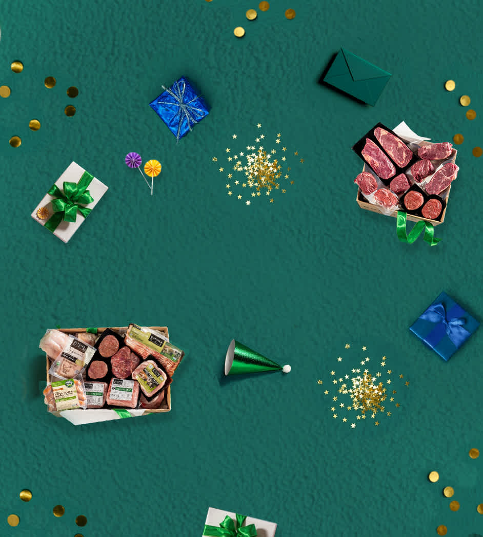 Two gift boxes full of beef, poultry, and seafood surrounded by balloons and birthday presents on a green background