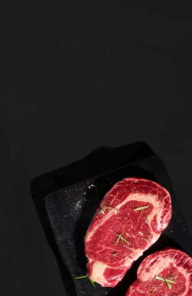 Raw steak on black background