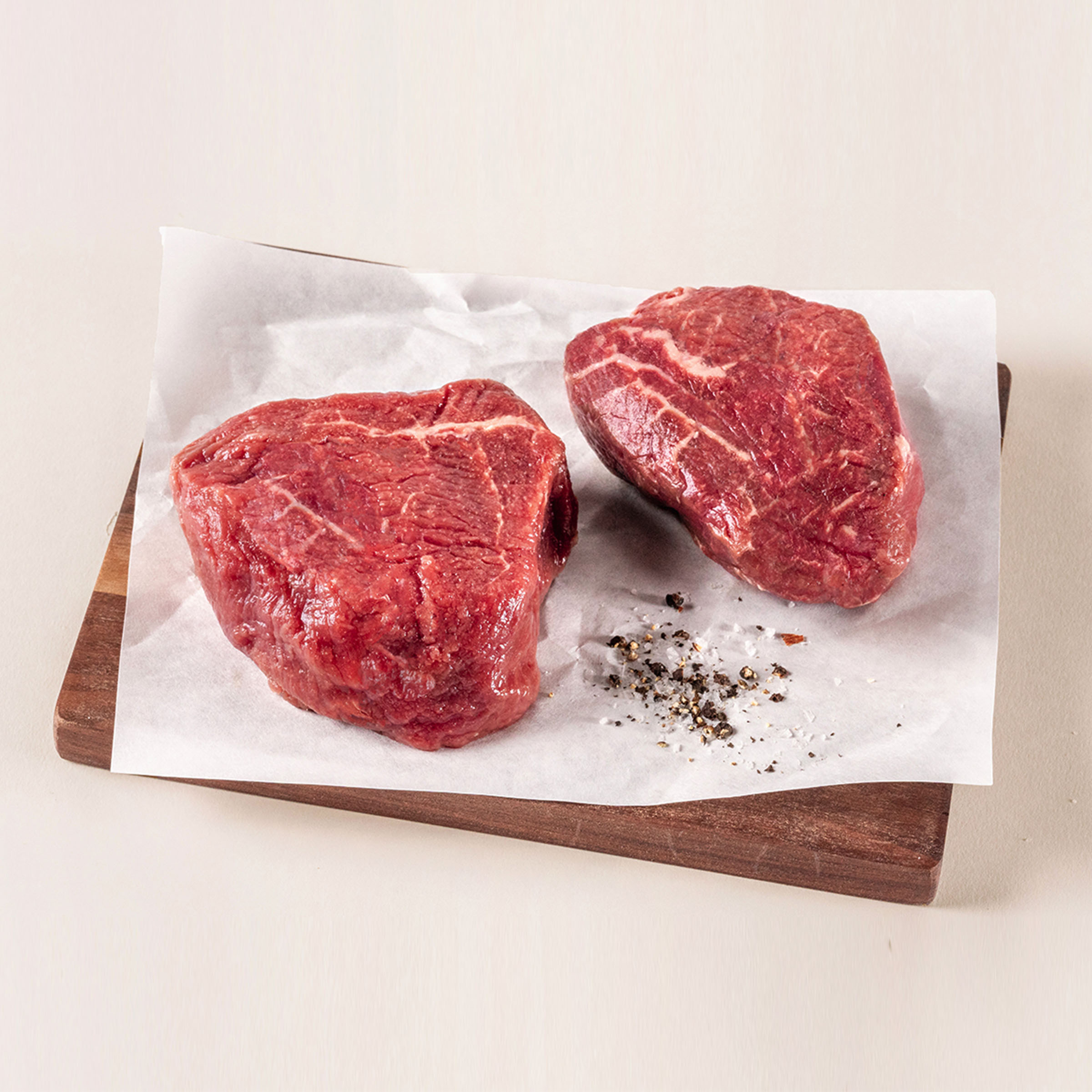 Raw filet mignons on cutting board