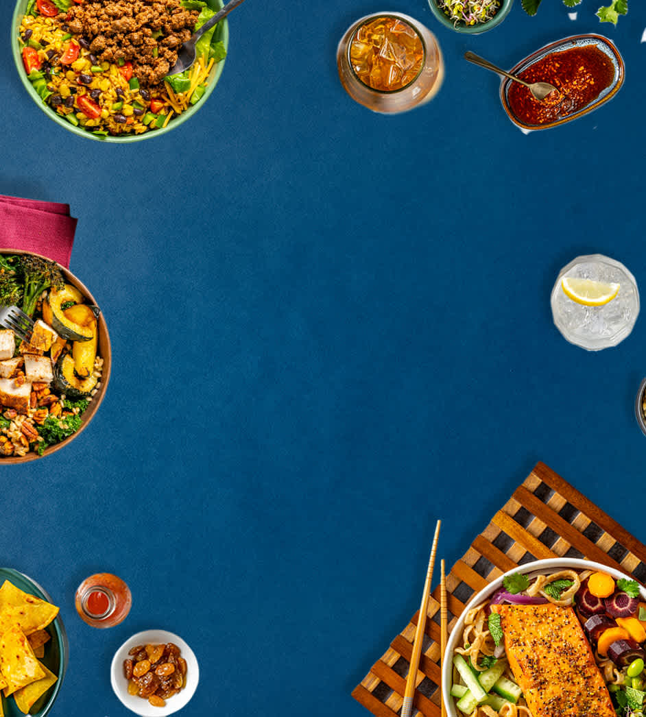Gift boxes full of meat, seafood, and poultry surrounded by festive balloons and ribbons on a blue background