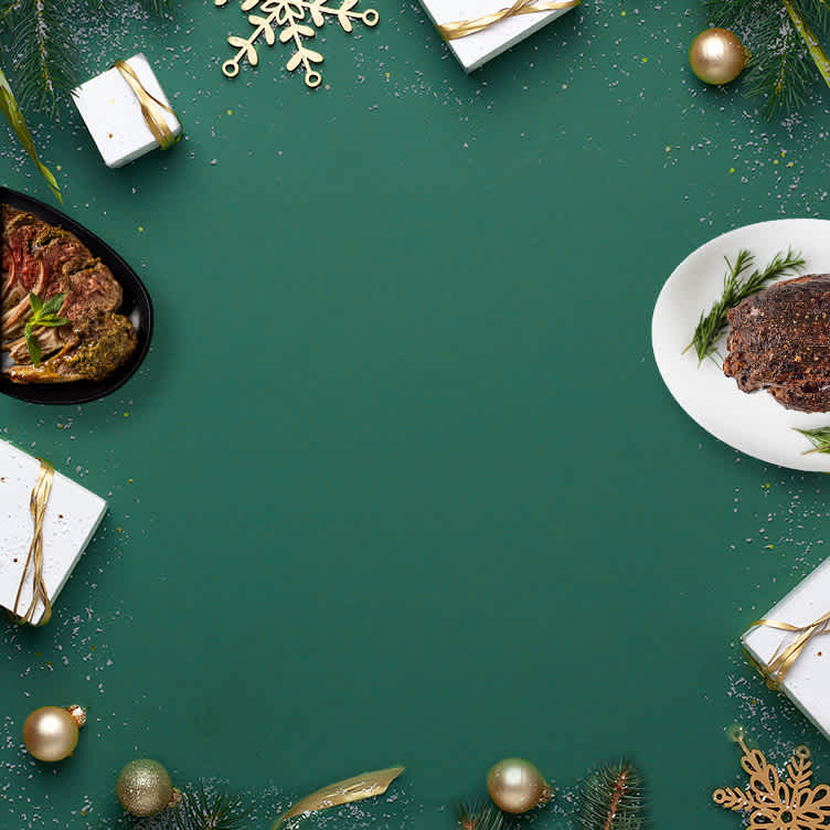 Gift boxes full of meat, seafood, and poultry surrounded by festive balloons and ribbons on a blue background