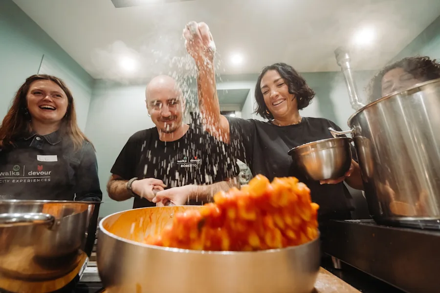 Chef Fernanda finishes a pot of gnocchi with a final sprinkle of seasoning during a gnocchi making class in Rome.