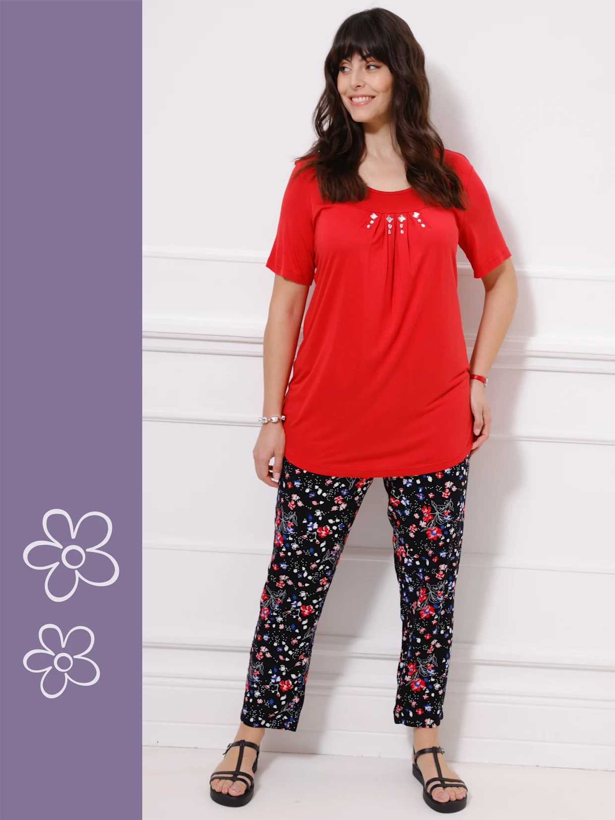 Červený dámský top s ozdobnými detaily a vzorované černé kalhoty s květinovým motivem. Červený dámský top s ozdobnými detaily a vzorované černé kalhoty s květinovým motivem.