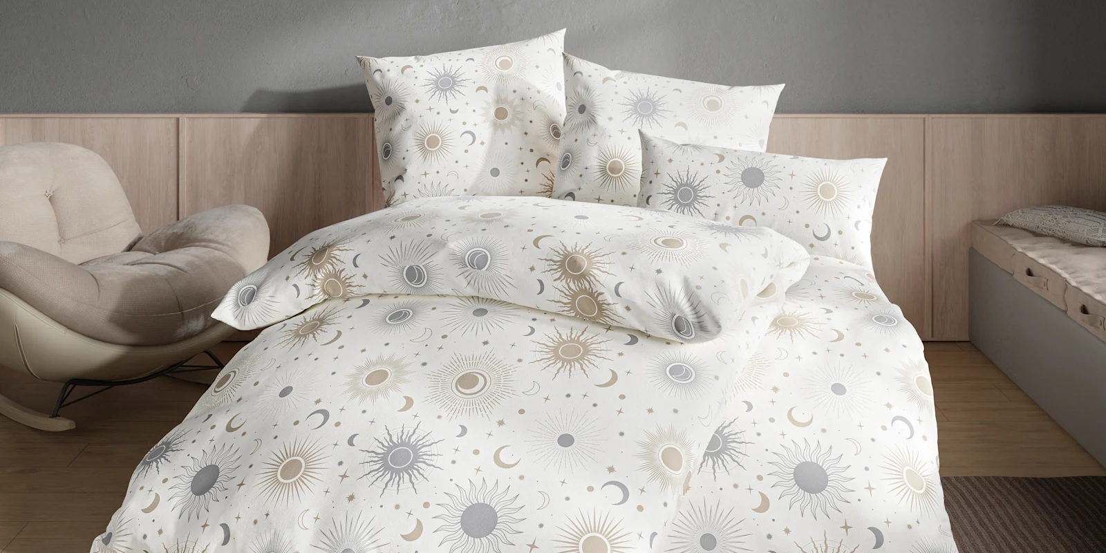 Bett mit weißer Bettwäsche mit Sonnen-, Mond- und Sternenmuster in einem Schlafzimmer.