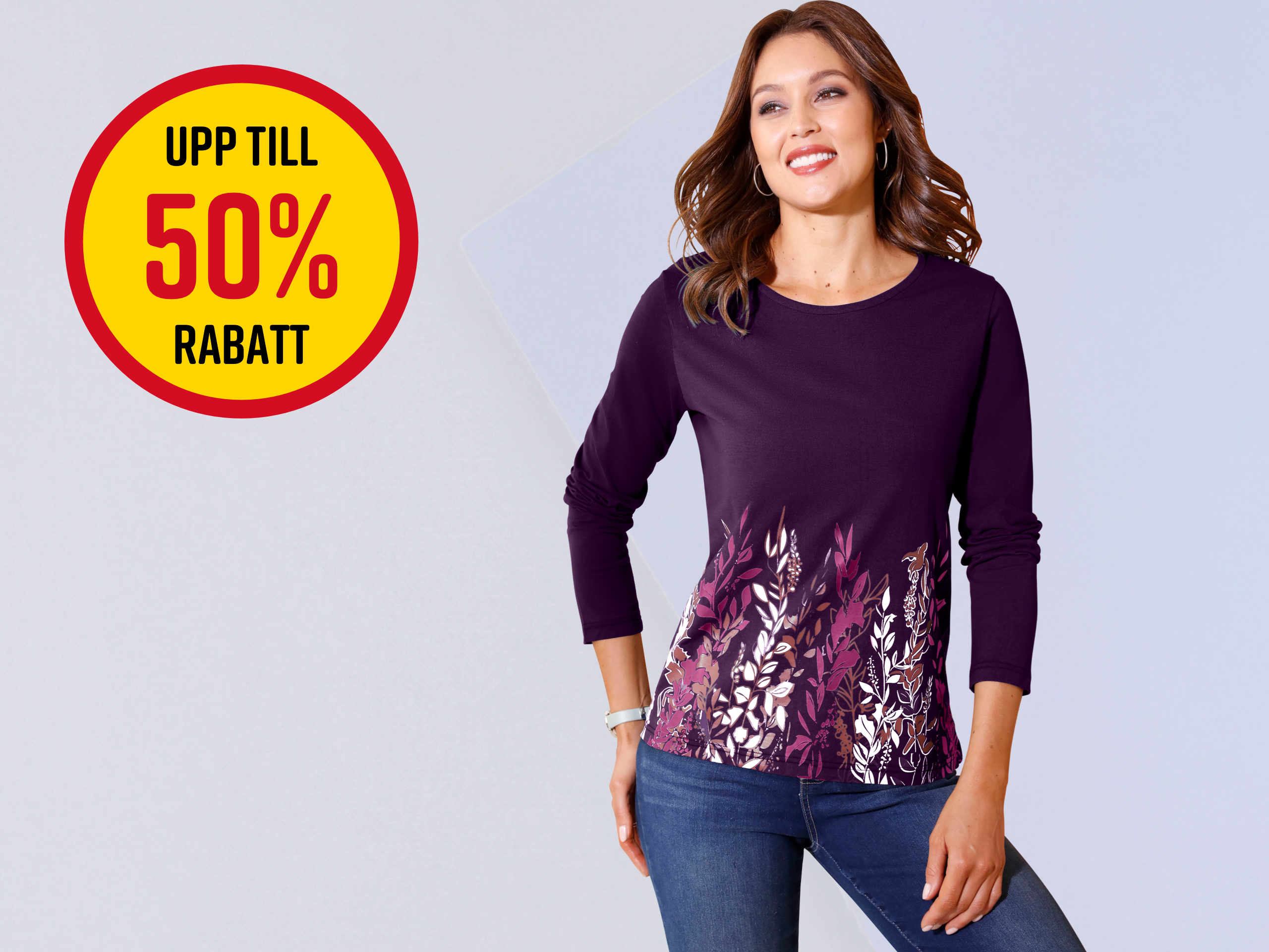 En modell bär en långärmad, mörklila tröja med blommönster, bredvid en stor rabattdekal med upp till 50%.