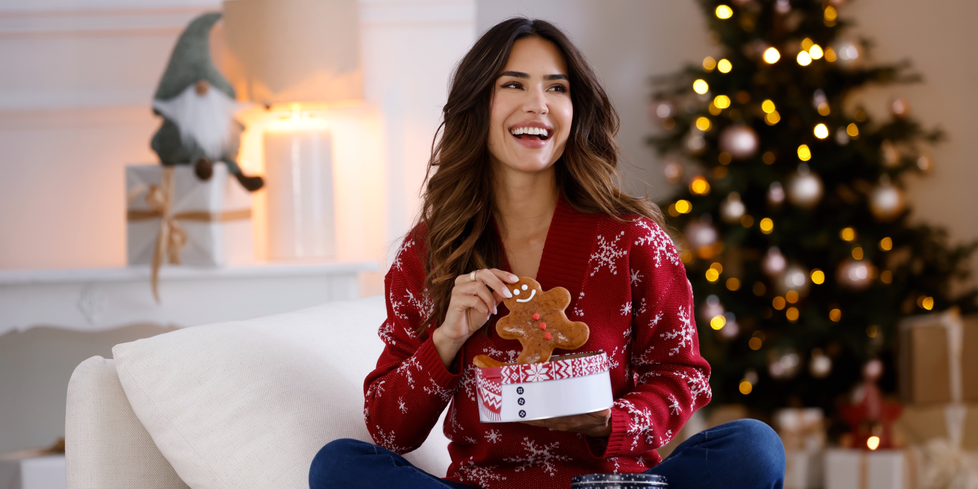 Ein lachendes Model im Weihnachtspullover. 