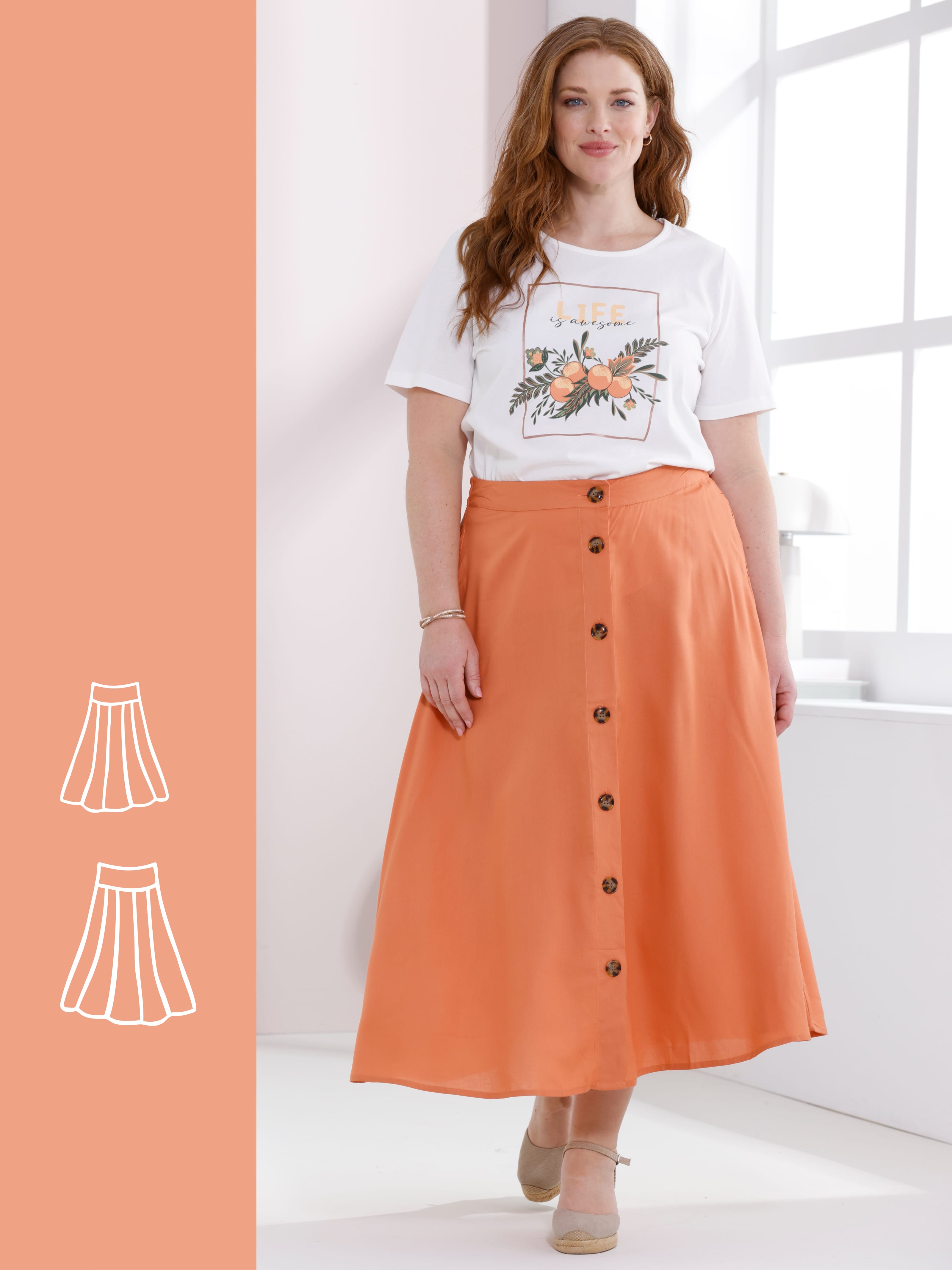 Ein Model trägt ein weißes T-Shirt mit Motiv und einen langen, orangefarbenen Rock mit Knopfleiste.