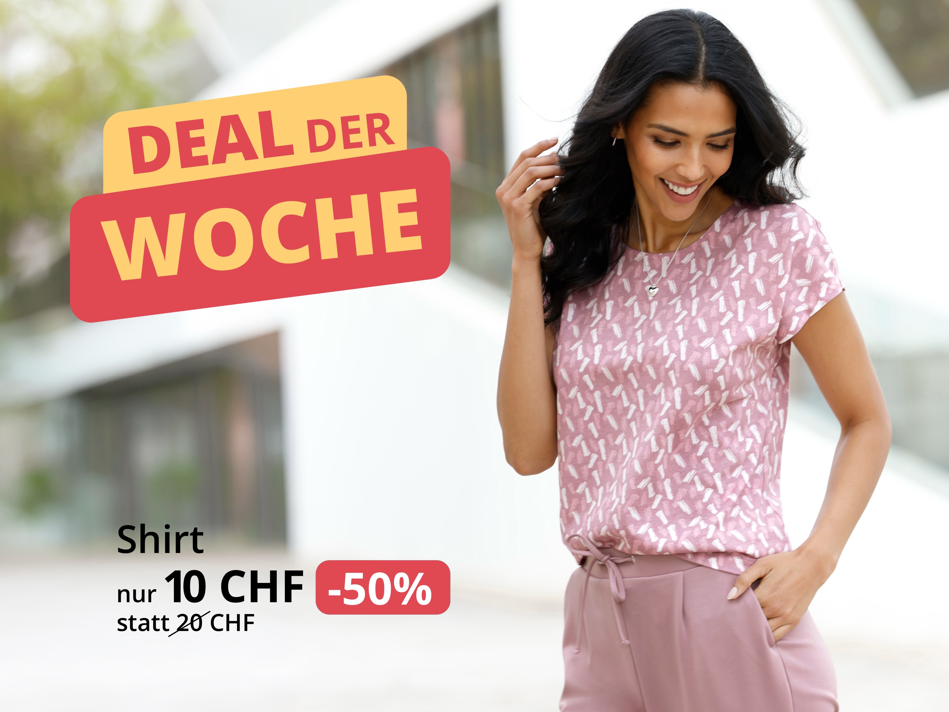 Ein Model trägt ein rosa gemustertes Kurzarmshirt und eine rosa Hose. Text: 'DEAL DER WOCHE', 'Shirt nur 10 CHF statt 20 CHF und '-50%'.