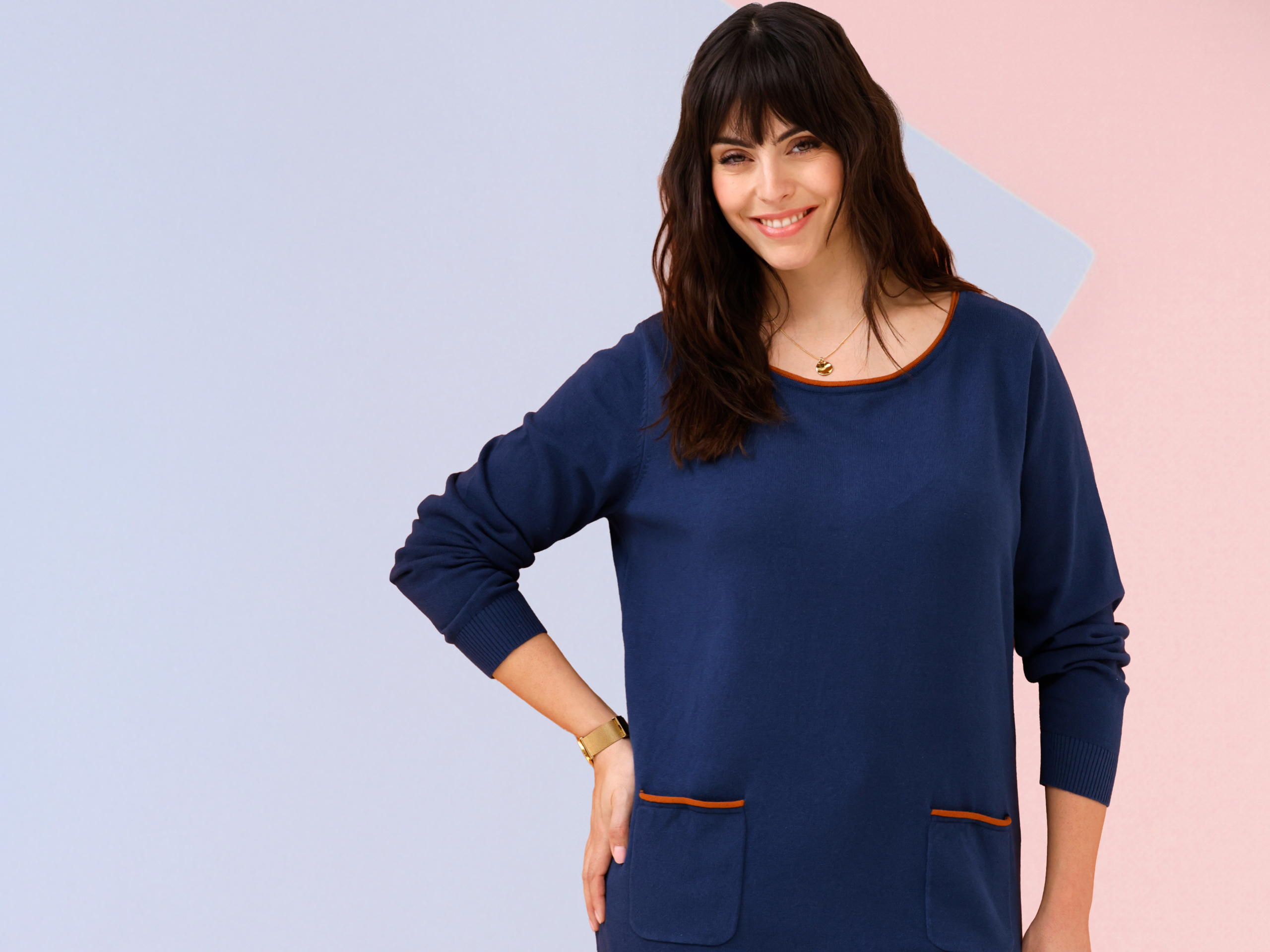 Twee modellen voor een oranje-witte achtergrond. Links een blauw shirt met zakken, rechts een oranje-zwart patroon vest.