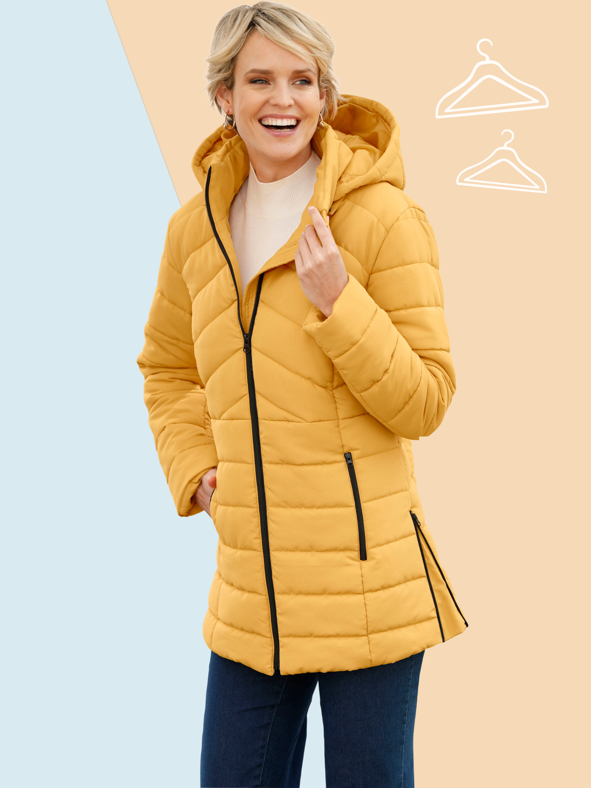 Ein Model trägt eine gelbe Steppjacke mit Kapuze und schwarzen Reißverschlüssen, kombiniert mit blauen Hosen vor zweifarbigem Hintergrund.