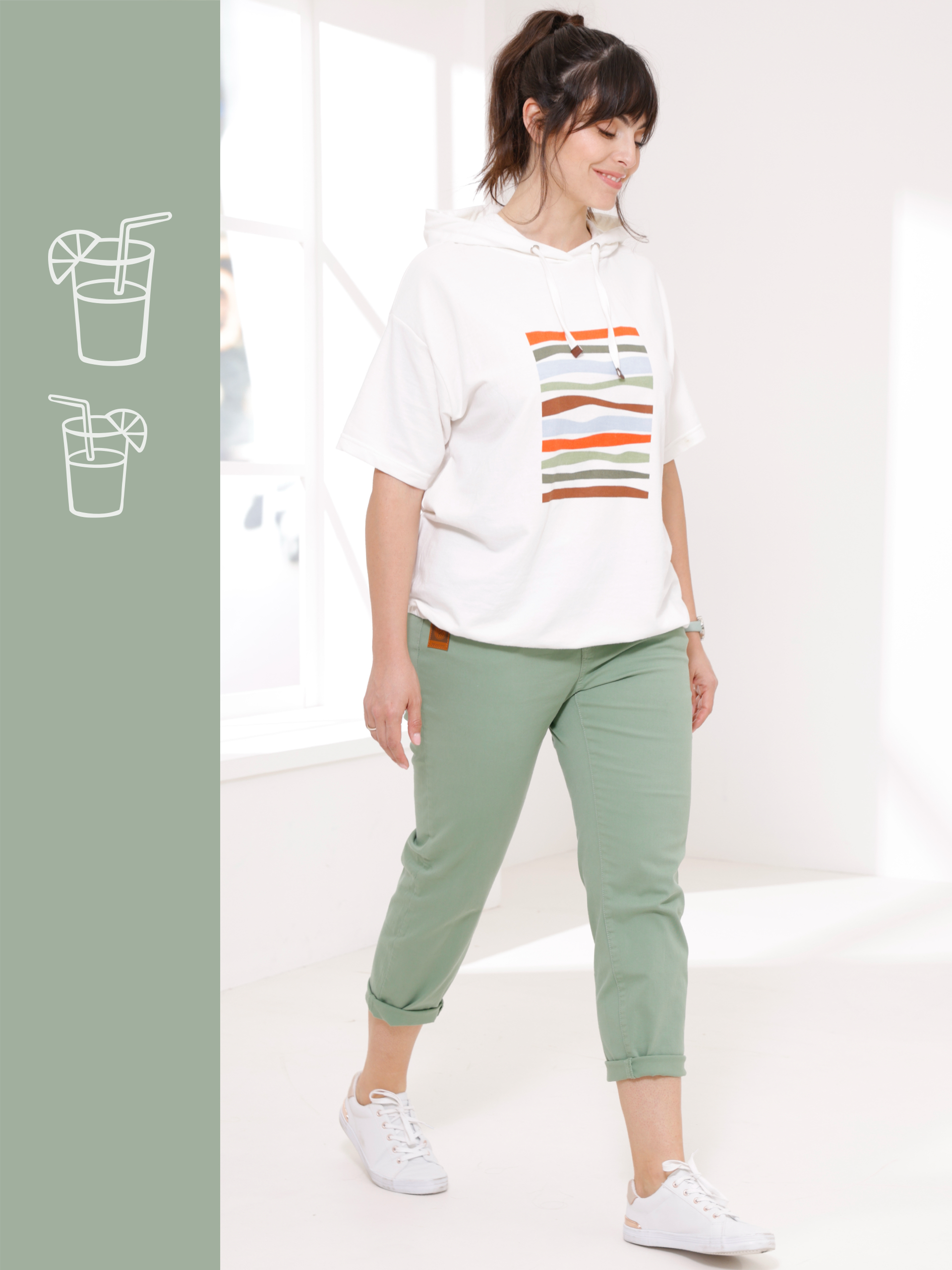 Weisses Shirt mit buntem Streifenmuster, kombiniert mit mintgrüner Hose und weißen Sneakern.