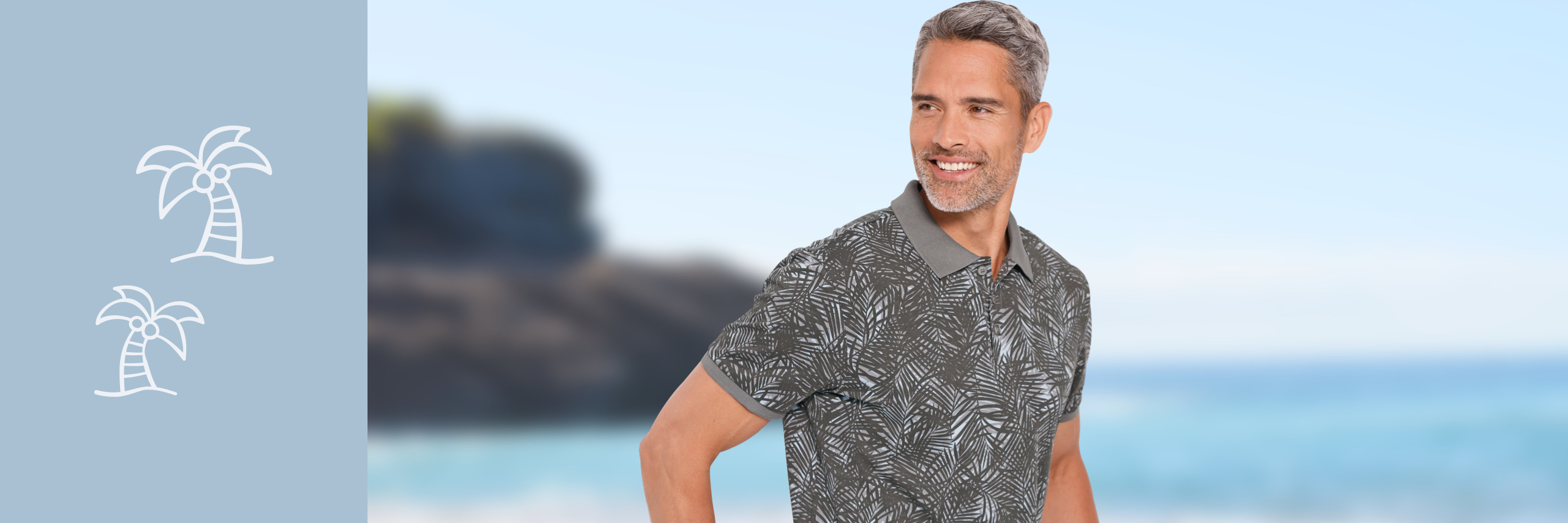 Ein Model trägt ein gemustertes Poloshirt und steht vor einem verschwommenen Meeres- und Felsenhintergrund.