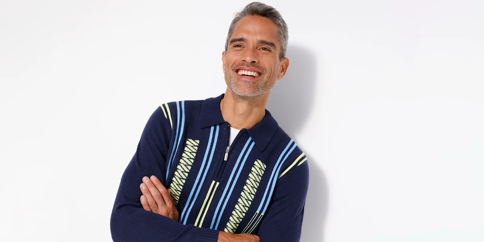 Een model draagt een donkerblauwe trui met rits en strepenpatroon.