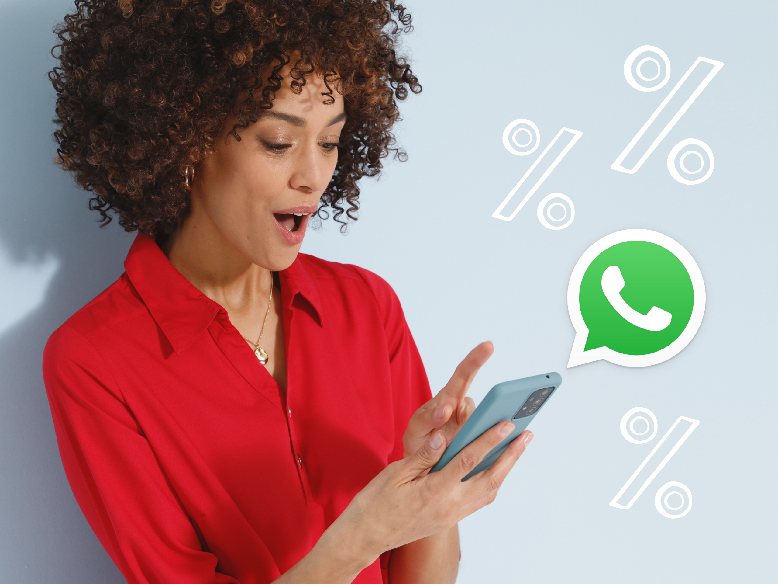 Ein Model mit rotem Hemd hält ein Smartphone, daneben sind Prozentzeichen und das WhatsApp-Logo.