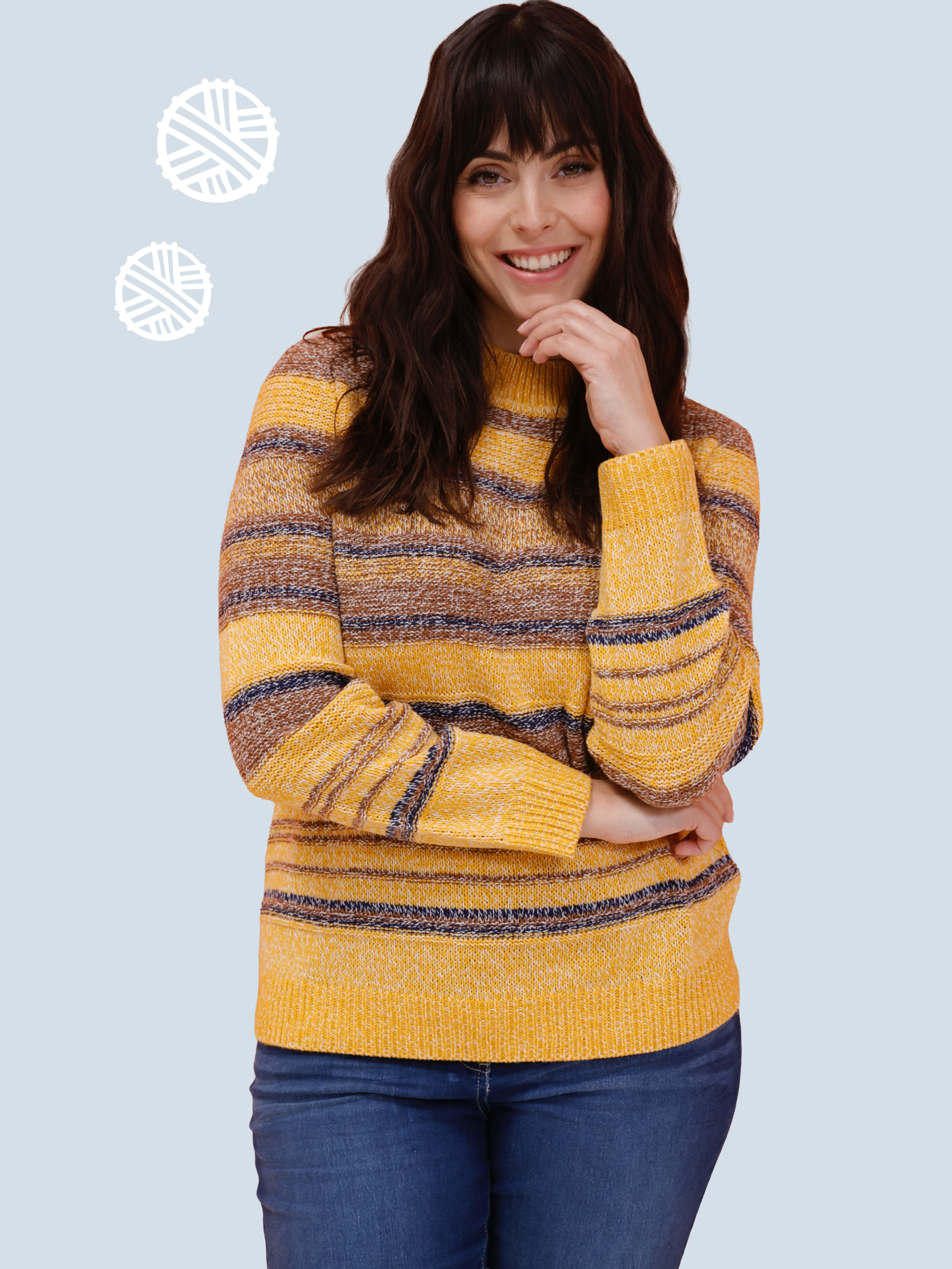 Model má na sebe pruhovaný sveter v žlto-hnedých tónoch a modré rifle.