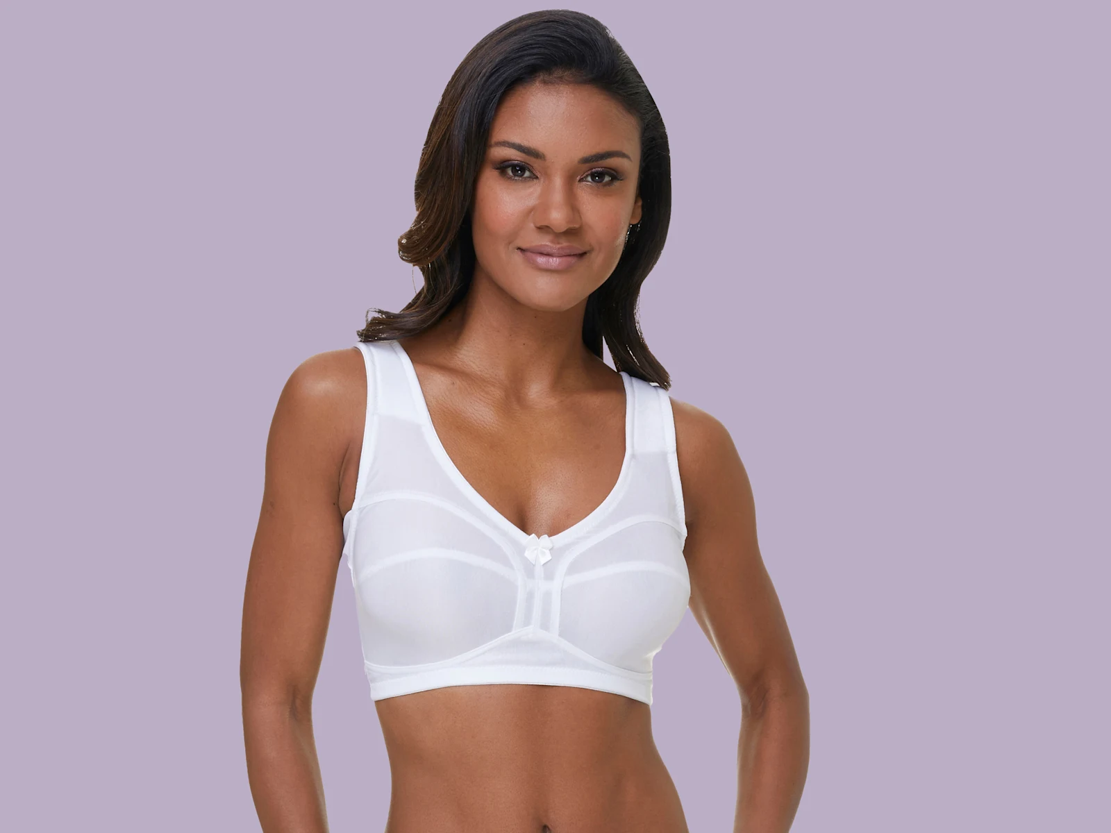 Bílá podprsenka bez kostic s širokými ramínky na fialovém pozadí.