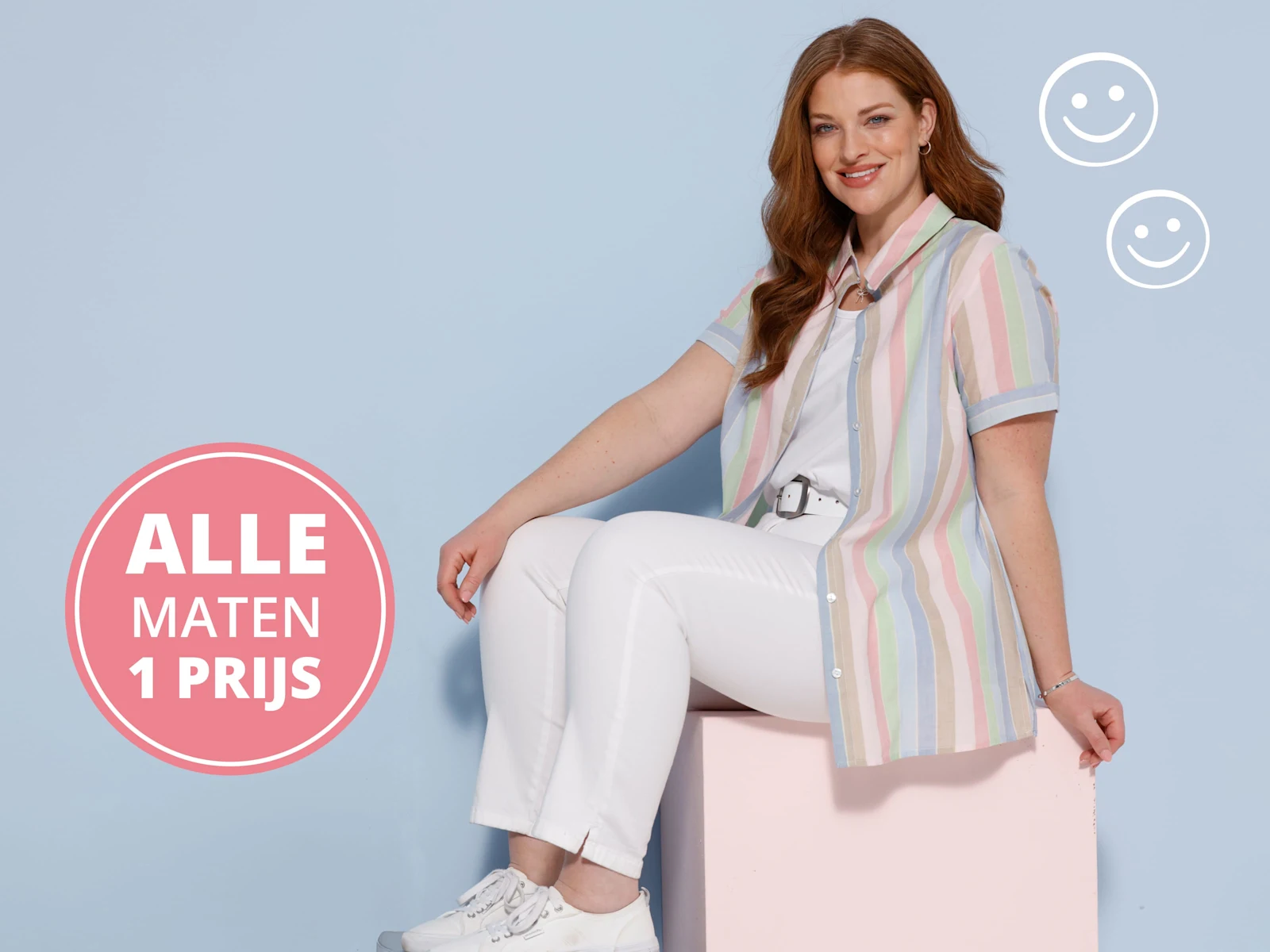 Een model met lang haar draagt een pastelgestreept blouse en witte broek, zit op een roze kubus voor een lichtblauwe achtergrond. Opschrift Alle maten één prijs.