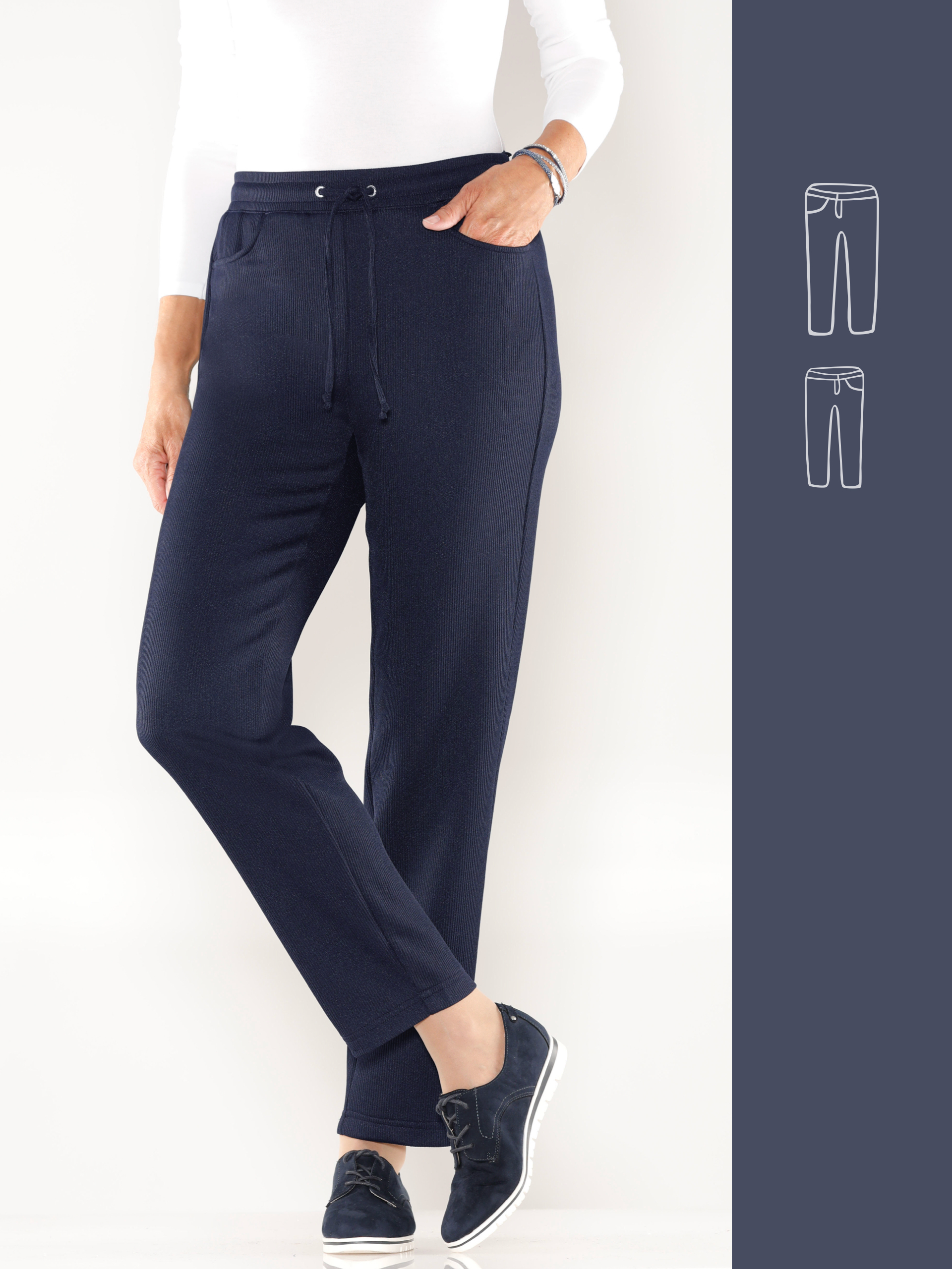 Ein Model trägt dunkelblaue, gerade geschnittene Stoffhosen mit Kordelzug und Taschen, kombiniert mit schwarzen Schuhen und weißem Oberteil.