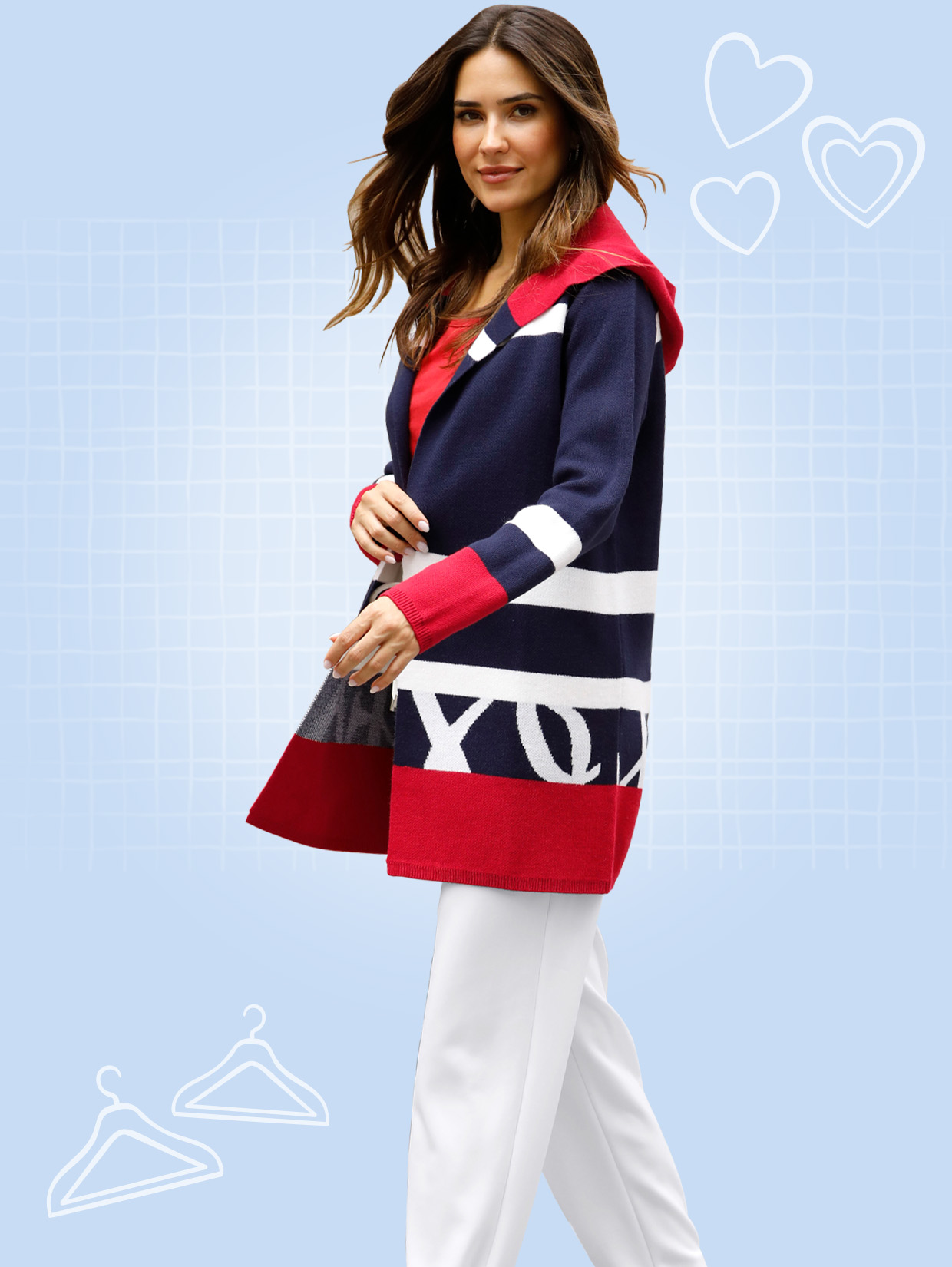 Model má na sobě dlouhý barevný pletený svetr s kapucí, bílé kalhoty a bílé tenisky.