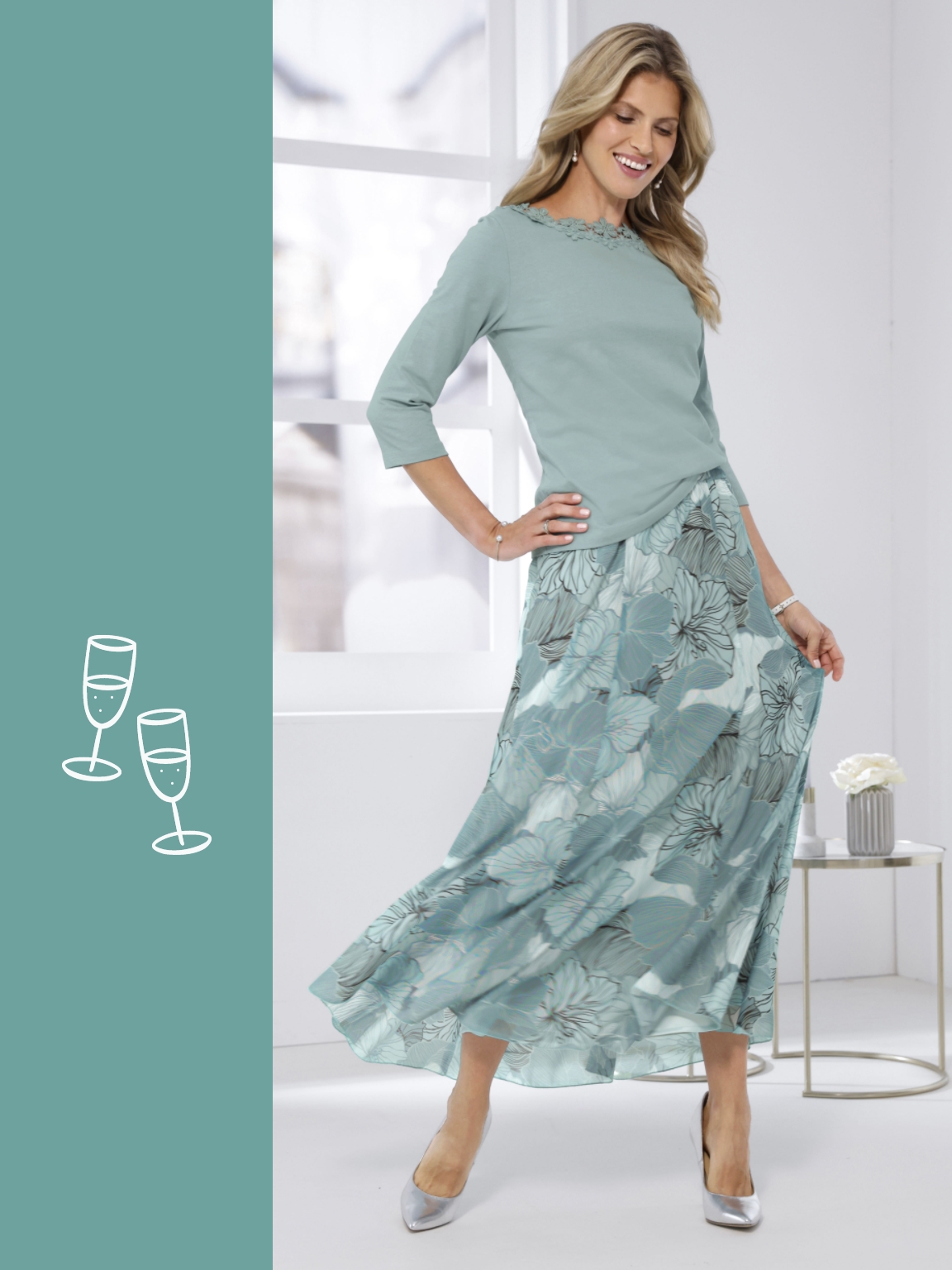 Model má na sobě mátově zelený top s 3/4 rukávy a mátově zelenou vzorovanou maxi sukni, stříbrné boty, na světlém pozadí.