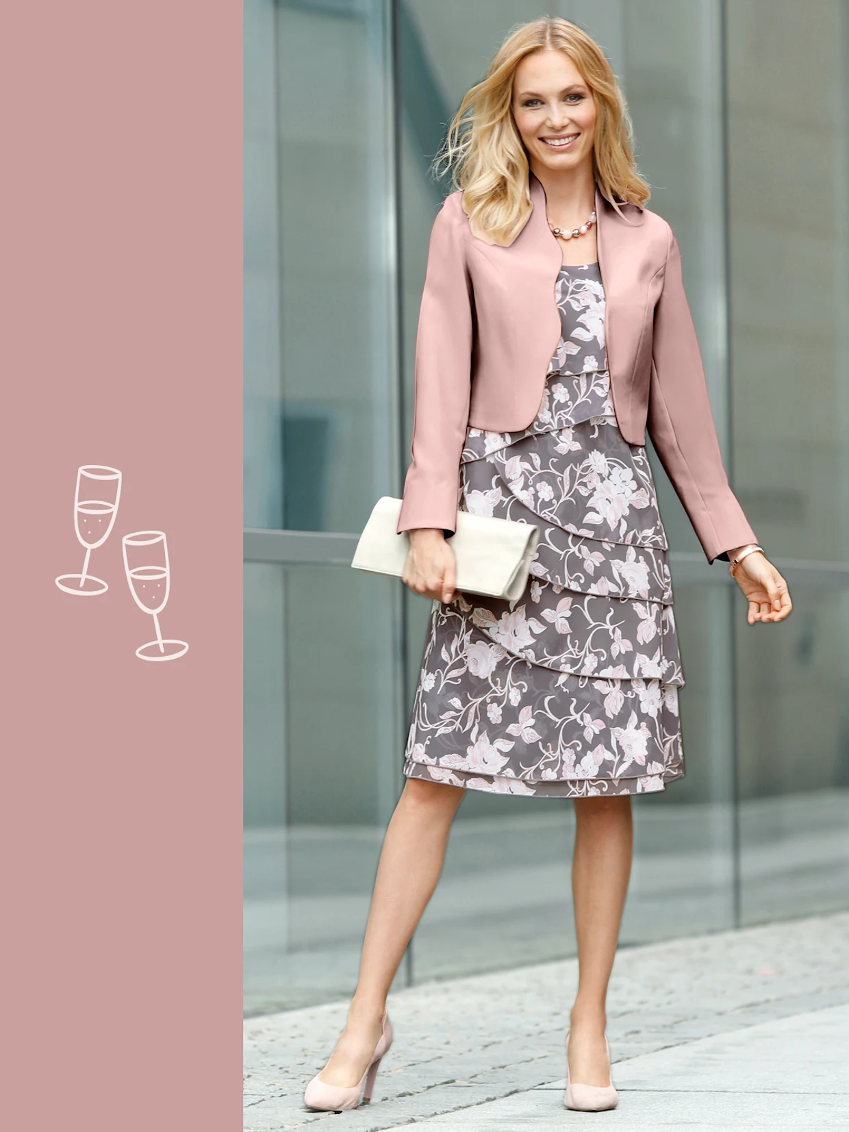 Frau in grauem Kleid mit Blumenmuster und einer roséfarbenen Jacke