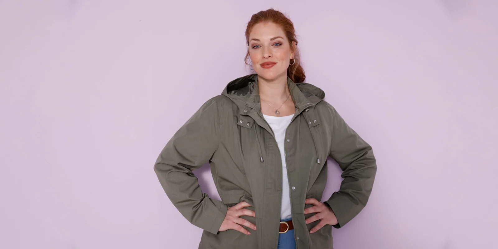 Model má oblečenú olivovozelenú bundu s kapucňou.