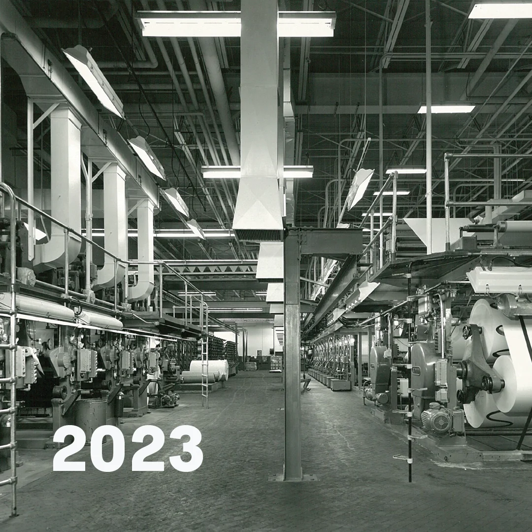 Overhead view of large group of factory employees standing on the floor of the factory
