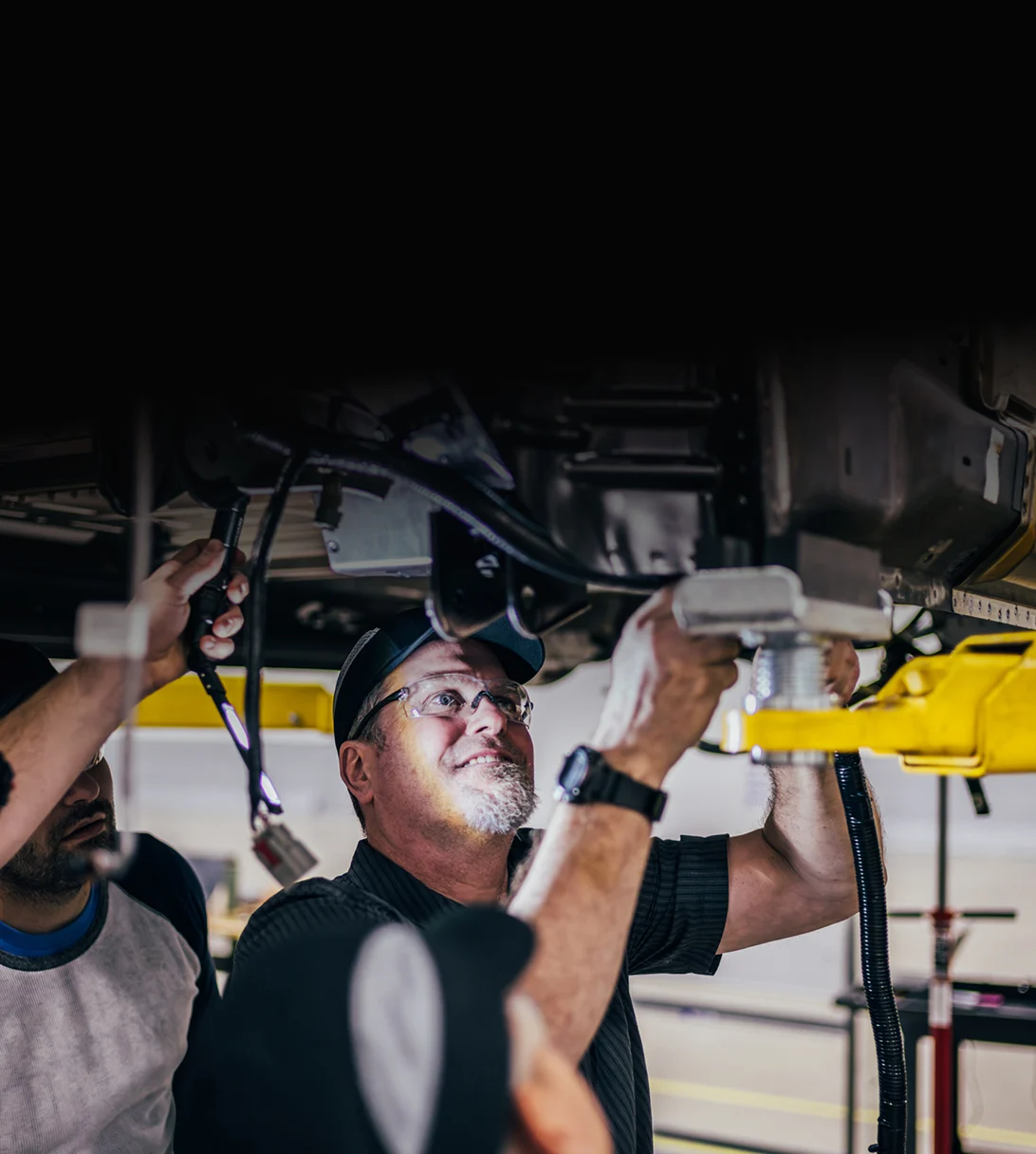 mechanic working on under carriage of truck