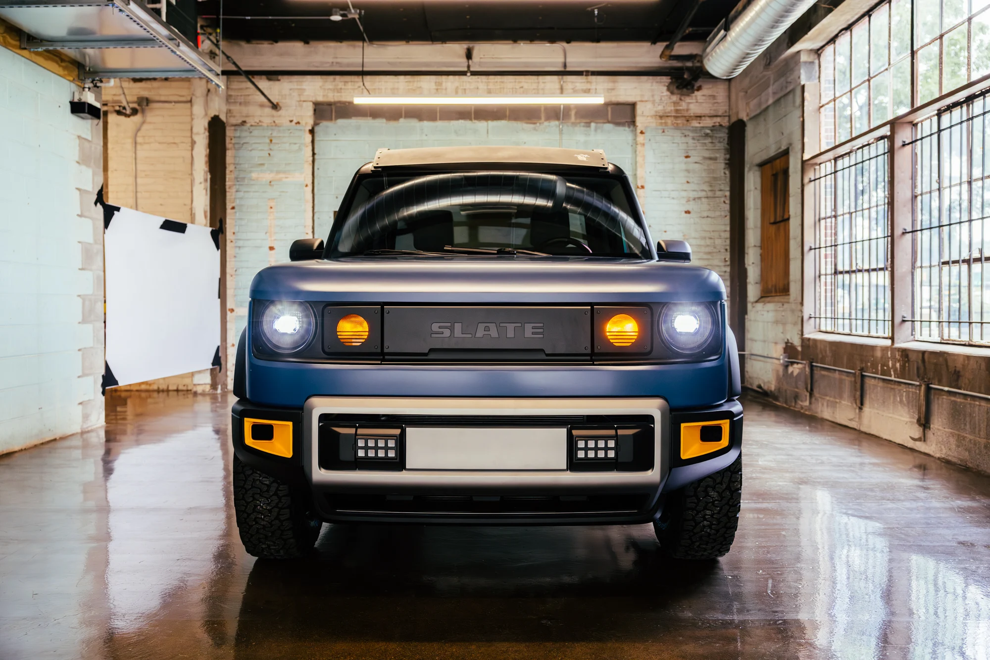 Front view of blue Slate Truck with lights on