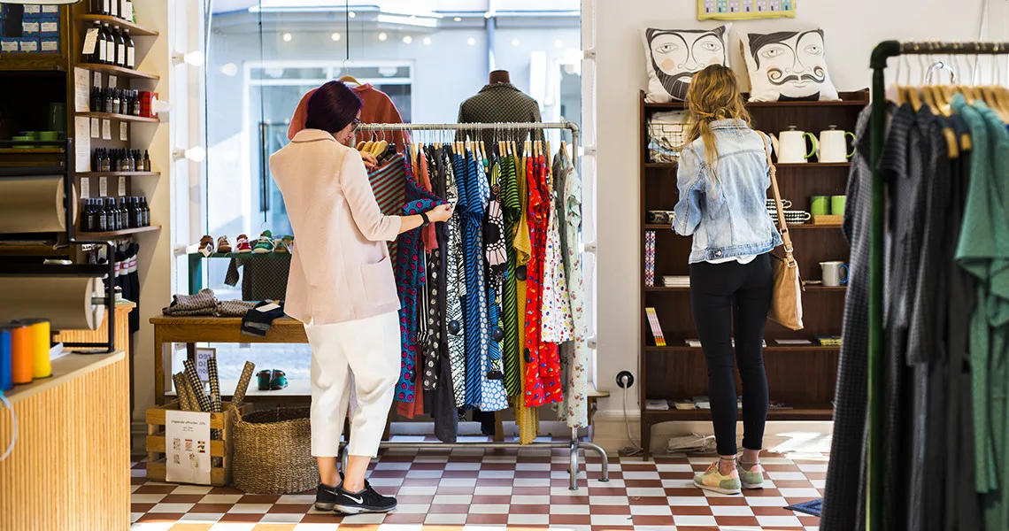 To kvinder kigger på tøj og møbler i en butik i Malmø.
