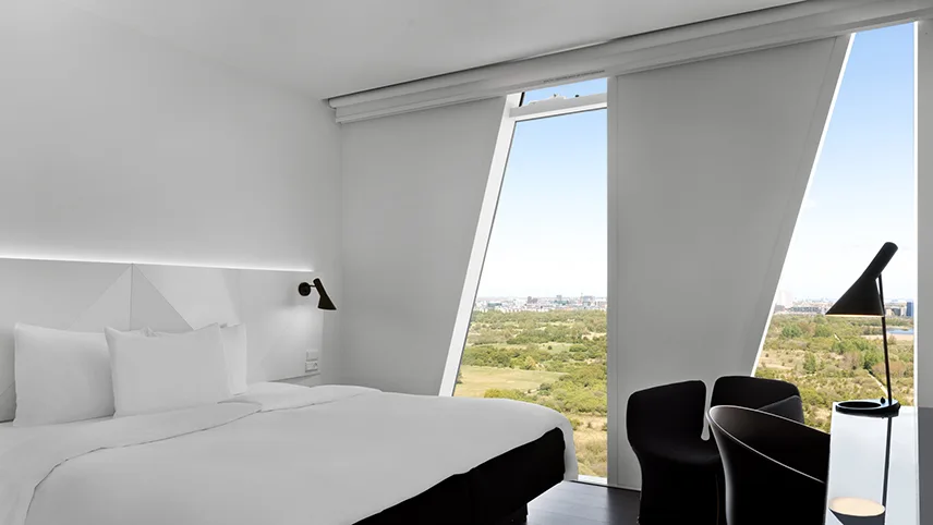Ett av rummen på hotellet, med stora fönster och utsikt över naturområdet Amager Fælled.