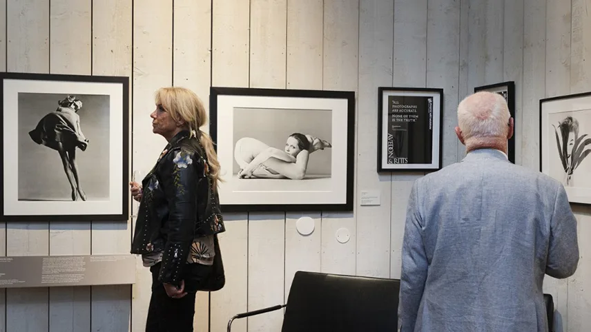 På Falsterbo Photo Art Museum i et lokale med rå trævægge og gæster der ser på fotokunst.