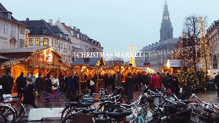 Julmarknad med marknadsstånd, julbelysning och många besökare i Köpenhamn